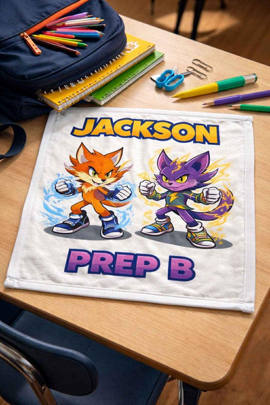 Personalized school napkin with cartoon cats, name Jackson, and Prep B on classroom desk