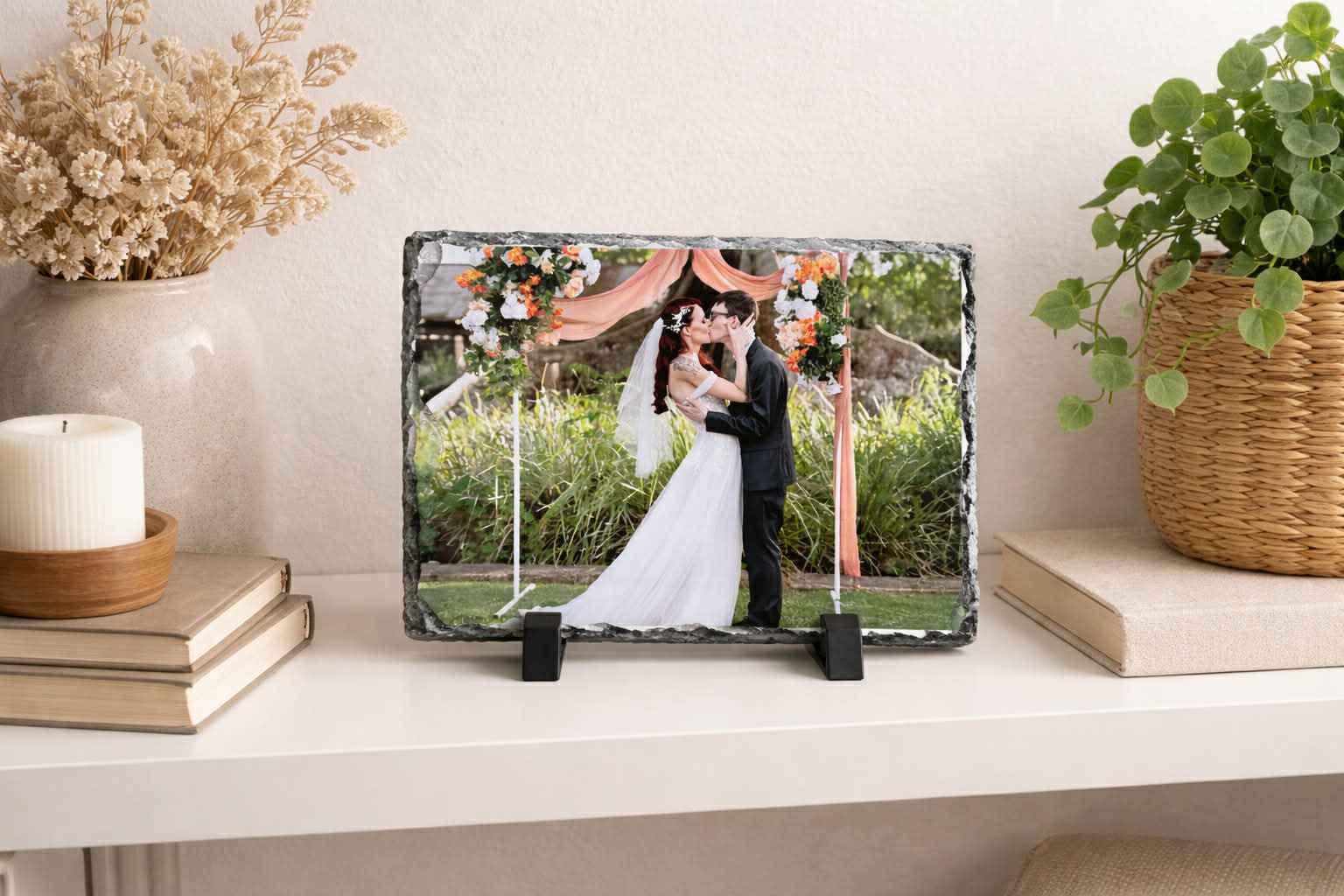 Personalised wedding photo slate display on a shelf with floral decor and greenery